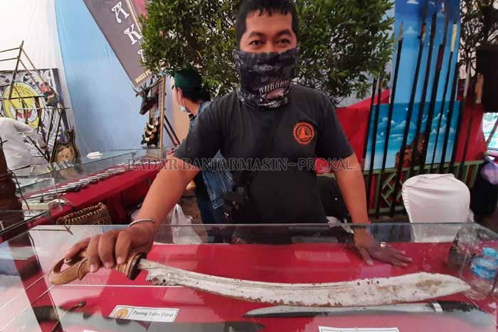 LANGKA: Seorang petugas pameran senjata tradisional memperlihatkan Parang Tabu Darat, Selasa (12/10). | FOTO: WAHYU RAMADHAN / RADAR BANJARMASIN
