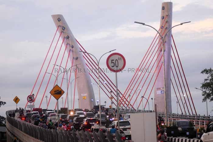 MENUNGGU JOKOWI: Warga melintasi Jembatan Basit di Batola. Jembatan ini akan dibuka tutup secara periodik hingga peresmian 21 Oktober mendatang.