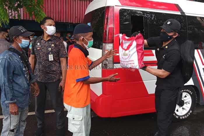 NGANTRE BANTUAN: Pasukan Pengamanan Presiden (Paspampres) membagikan bingkisan berisi bantuan sembako kepada warga sekitar kawasan Pasar Sudimampir Raya. | Foto: Wahyu Ramadhan/Radar Banjarmasin