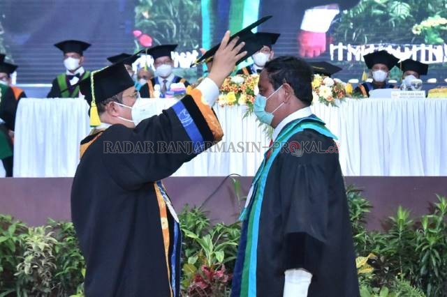 JADI DOKTOR KEHORMATAN: Gubernur Kalsel Sahbirin Noor saat dianugerahi gelar doktor kehormatan honoris Causa (Dr. HC) oleh Universitas Lambung Mangkurat (ULM) kemarin (28/10) di Gedung Auditorium ULM Banjarbaru. | FOTO: RIFANI/RADAR BANJARMASIN