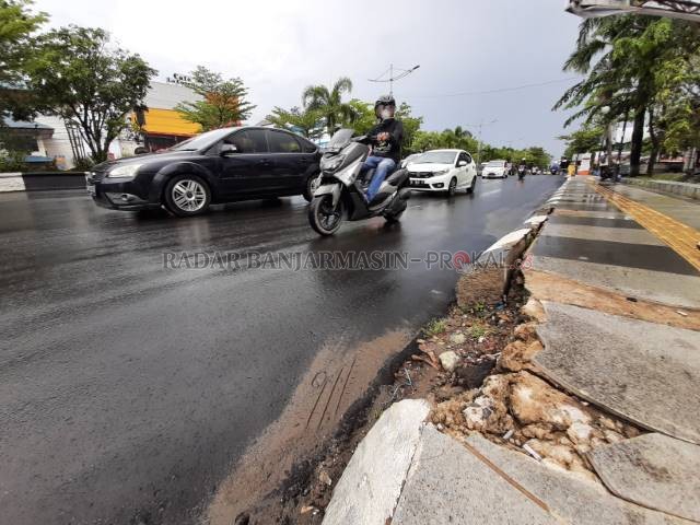 SUDAH RUSAK: Pembatas trotoar dan badan jalan yang jebol di Jalan Ahmad Yani kilometer enam. Kerusakan serupa juga tampak di titik lain. | FOTO: WAHYU RAMADHAN/RADAR BANJARMASIN