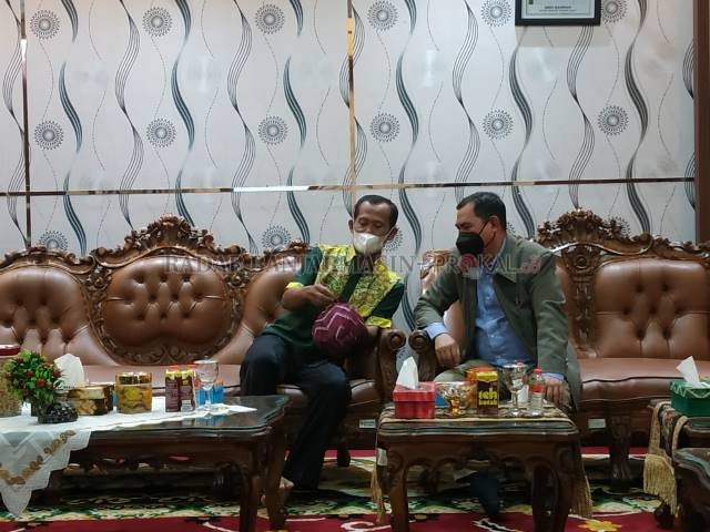 AKRAB: Bupati Tala HM Sukamta memperlihatkan kopiah kepada Ketua PWI Kalsel Zainal Helmie.