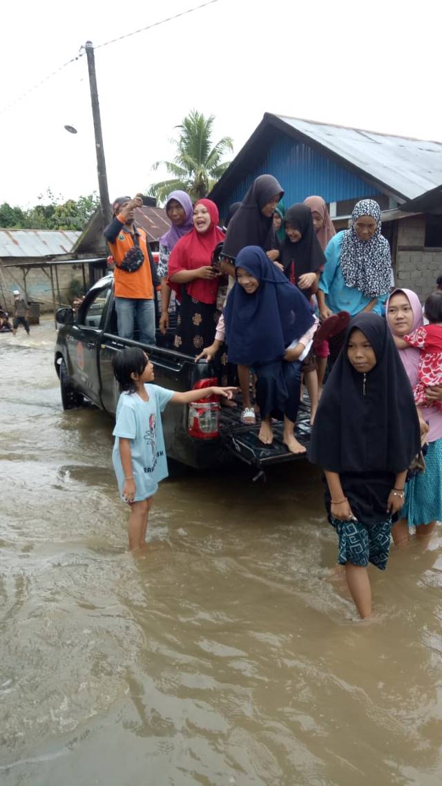 MENGUNGSI : TRC BPBD Balangan saat membantu warga untuk evakuasi ke tenpat lebih tinggi. | FOTO: TRC FOR RADAR BANJARMASIN.