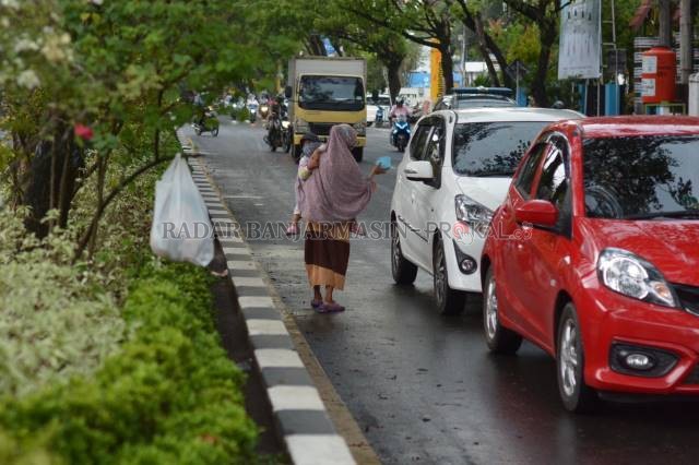 MENGIBAKAN: Pengemis kerap membawa anaknya ke jalan untuk memancing simpati pengendara. Foto ilustrasi diambil di Banjarmasin, belum lama ini.