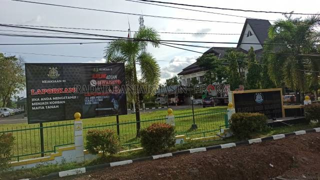 BURU MAFIA TANAH: Baliho imbauan di pagar Kantor Kejari Banjarbaru. Baliho serupa banyak ditemukan di tempat-tempat publik. | FOTO: SUTRISNO/RADAR BANJARMASIN