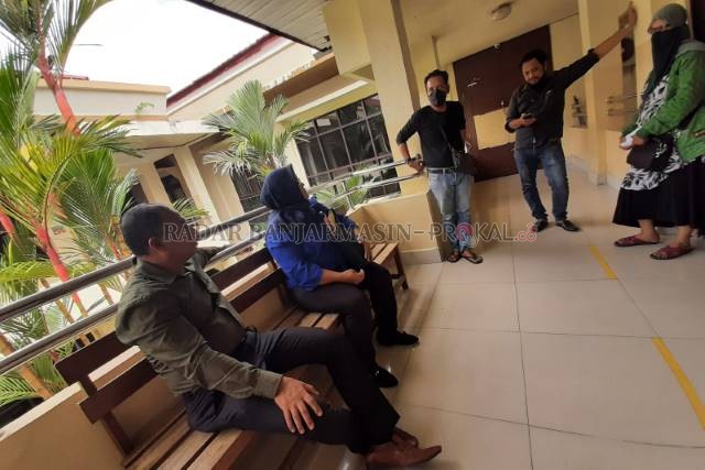 PENGACARA: Syamsu Saladin dan Wahyu Utami duduk menunggu di luar ruang sidang di Pengadilan Negeri Banjarmasin, kemarin. | FOTO: WAHYU RAMADHAN/RADAR BANJARMASIN