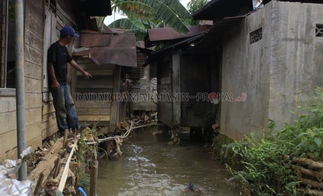DIHIMPIT BANGUNAN: Normalisasi sungai Kuranji yang kerap meluber ketika diguyur hujan deras terkendala dengan keberadaan rumahrumah warga di kedua sisi sungai. | FOTO: MUHAMMAD RIFANI/RADAR BANJARMASIN