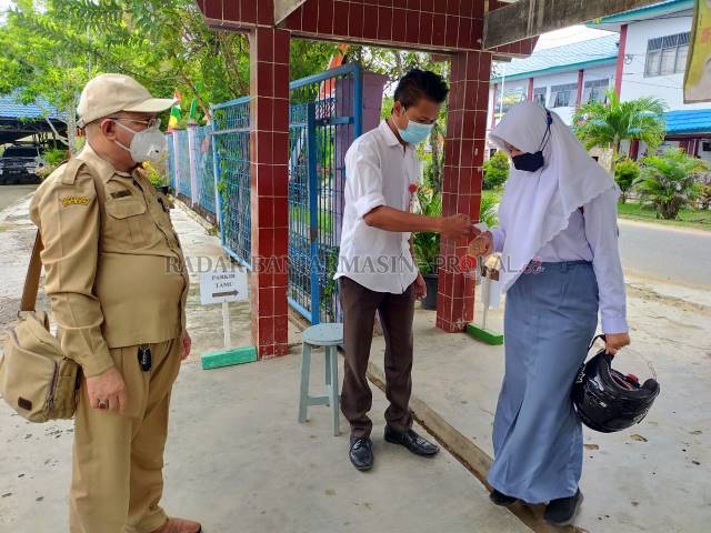 TES SUHU: Siswa di Hulu Sungai Utara diperiksa suhu saat masuk sekolah belum lama tadi.