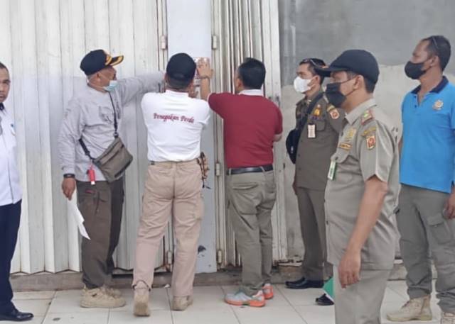 DITUTUP PAKSA: Satpol PP Banjarbaru menempel stiker penyegelan kafe D’Legend yang sebelumnya kedapatan melanggar aturan serta tepergok ada empat botol miras di dalamnya. Kafe ini dilarang beroperasi selama satu bulan penuh. | FOTO: SATPOL PP BANJARBARU FO