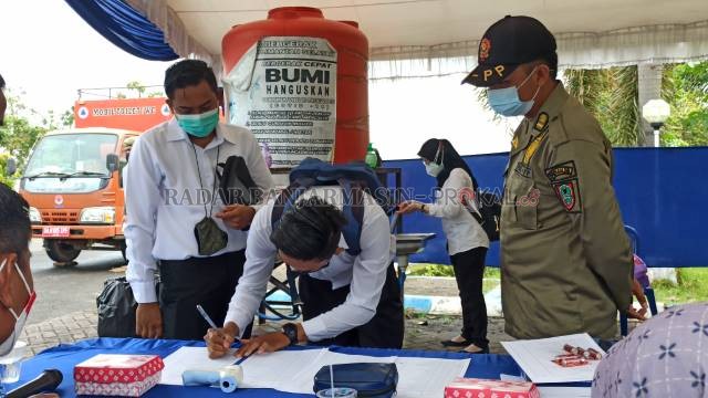MENGISI DAFTAR HADIR: Para peserta saat mengikuti Seleksi Kompetensi Bidang (SKB) untuk Calon Pegawai Negeri Sipil (CPNS) 2021 lingkup Pemprov Kalsel, kemarin. | FOTO:   SUTRISNO/RADAR BANJARMASIN