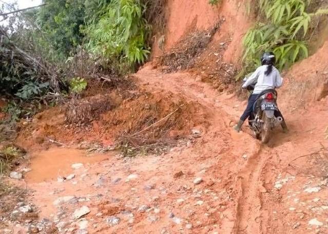 AKSES SULIT: Para guru di SDN Muara Hungi, Kecamatan Batang Alai Timur (BAT), Kabupaten Hulu Sungai Tengah, ketika melewati jalan longsor menuju ke sekolah, Selasa (7/12). | Foto: Herlinawati For Radar Banjarmasin