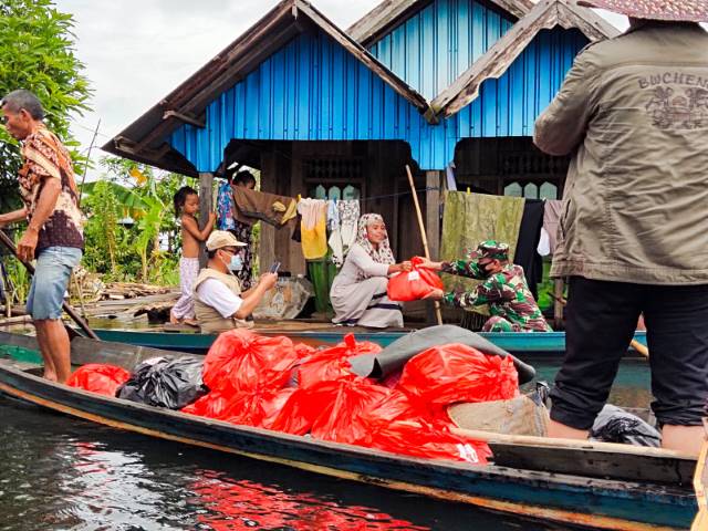 PAKAI JUKUNG: Warga terdampak banjir di Labuan Amas Utara dibantu sembako. | foto: Kodim 1002/HST FOR RADAR BANJARMASIN