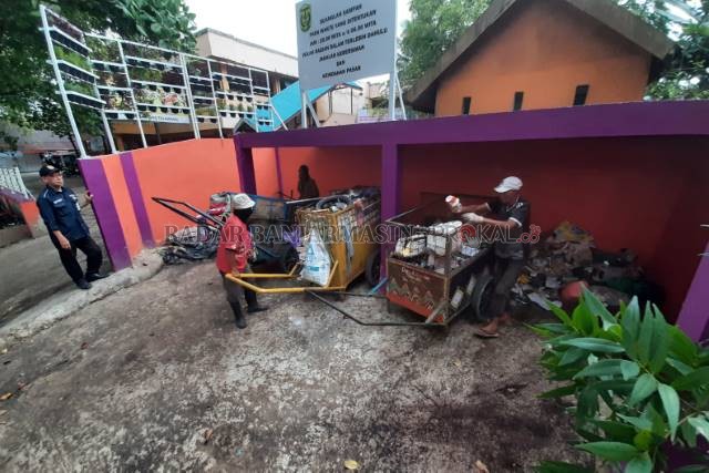 TERTIB: Petugas Disperdagin Kota Banjarmasin mengawasi warga yang membuang sampah di TPS Pasar Telawang, Selasa (21/12) petang.