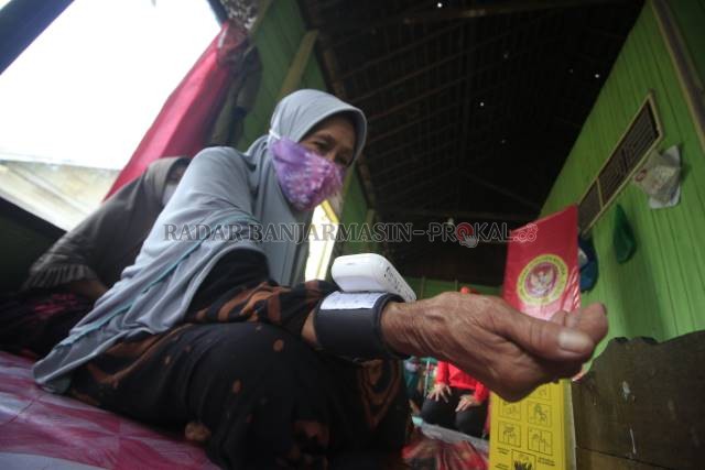 CEK TENSI: Salah seorang lansia di wilayah Cempaka diperiksa tensi darahnya sebelum disuntik vaksin beberapa waktu lalu. Target cakupan vaksinasi lansia sebesar 60 persen di Banjarbaru dianggap sulit terkejar sampai akhir tahun ini. | Foto: Muhammad Rifan
