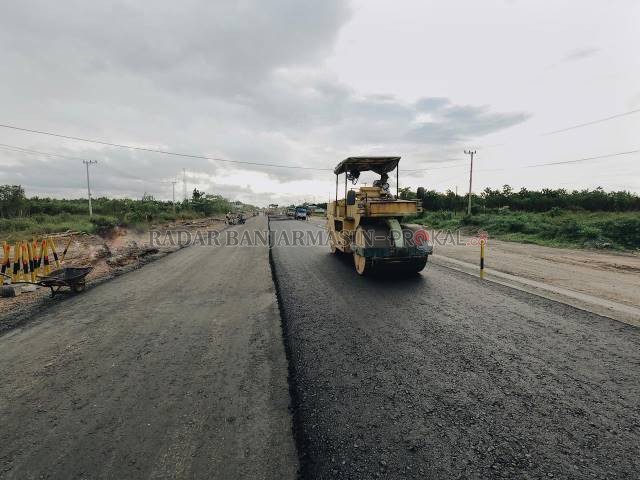 MULAI BAGUS: Pekerja mengaspal Jalan Gubernur Syarkawi, kemarin. Pertengahan tahun tadi, ruas jalan ini tak bisa ditembus karena rusak parah. | FOTO: M OSCAR FRABY/RADAR BANJARMASIN