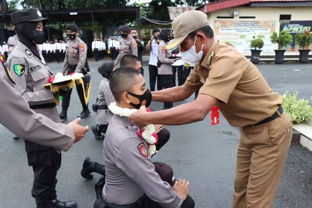 KALUNGKAN: Bupati Tala HM Sukamta mengalungkan kalungan bunga kepada bintara muda baru.