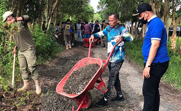 KEKELUARGAAN: Bupati Tala HM Sukamta bersama masyarakat Desa Takisung melakukan gotong royong perbaikan jalan desa.