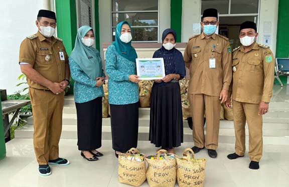 SOSIAL: Ketua Tim Penggerak PKK Kabupaten Tanah Bumbu Wahyu Windarti Zairullah menyerahkan bantuan paket sembako dari Dinas Sosial Kalsel di kantor Kecamatan Kusan Hilir