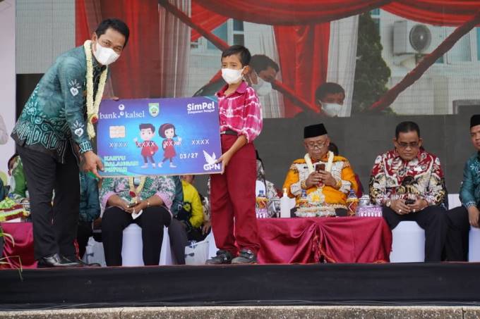 LAUNCHING : Bupati Balangan, Abdul Hadi (kiri) saat secara simbolis memberikan Kartu Balangan Pintar (KBP) kepada salah seorang pelajar yang berhak menerima. : FOTO WAHYUDI RADAR BANJARMASIN.