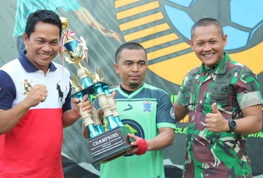 APRESIASI : Bupati Balangan, Abdul Hadi (kiri) menyerahkan trofi juara kepada pemenang Turnamen Sepakbola antar instansi Bupati Cup 2022. : FOTO MC FOR RADAR BANJARMASIN.