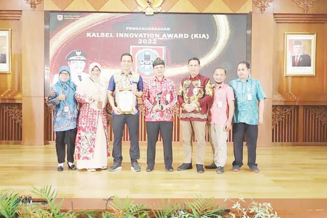 BANGGA: Asisten Bidang Perekonomian dan Pembangunan Ahmad Hairin (tengah) menerima trofi juara III lomba Kalsel Innovation Award (KIA) Tahun 2022 untuk Aplikasi SILAKAS dari Disdukcapil Tala. | Foto : Prokopim For Radar Banjarmasin