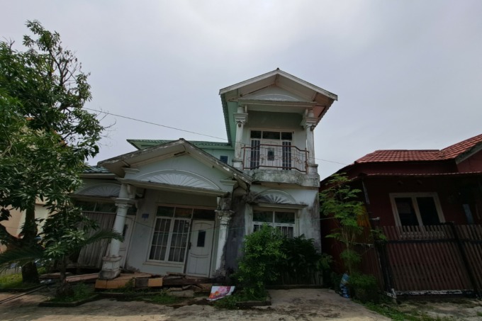 NYARIS AMBRUK: Belasan tahun ditinggal penghuninya ke Bali, rumah di kawasan Kompleks Surya Sakti Jalur 10 RT 26 Kelurahan Basirih, Kecamatan Banjarmasin Barat miring hendak roboh. | FOTO: WAHYU RAMADHAN/RADAR BANJARMASIN