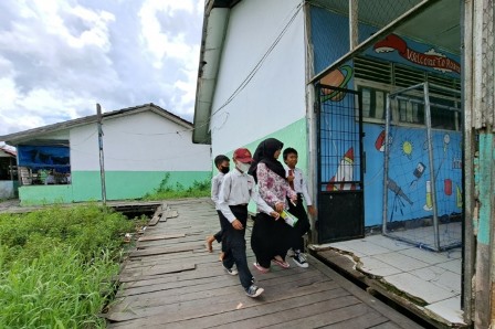 TAMBAL SULAM: Akses jalan titian yang digunakan guru serta siswa siswi di SDN Basirih 3 Banjarmasin. | FOTO: WAHYU RAMADHAN/RADAR BANJARMASIN