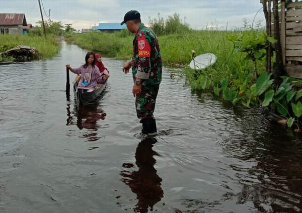 MASIH CALAP: Warga Desa Sungai Buluh menggunakan jukung untuk aktivitas sehari-sehari selama perkampungannya kebanjiran. | FOTO KODIM1002/HST FOR RADAR BANJARMASIN