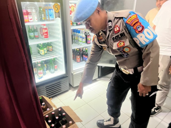 SIAP DIJUAL: Personel Polres Banjarbaru memperlihatkan ratusan botol miras yang berhasil dijaring saat razia miras di salah satu toko di wilayah Panglima Batur Banjarbaru. | Foto: Polres Banjarbaru for Radar Banjarmasin