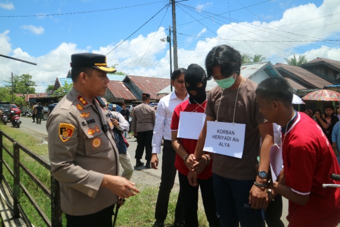 PRA REKONTRUKSI: Kedua pelaku dibawa ke lokasi kejadian memperagakan pembunuhan yang mereka lakukan. Korban diperankan seorang polisi. | FOTO: RASIDI FADLI/RADAR BANJARMASIN