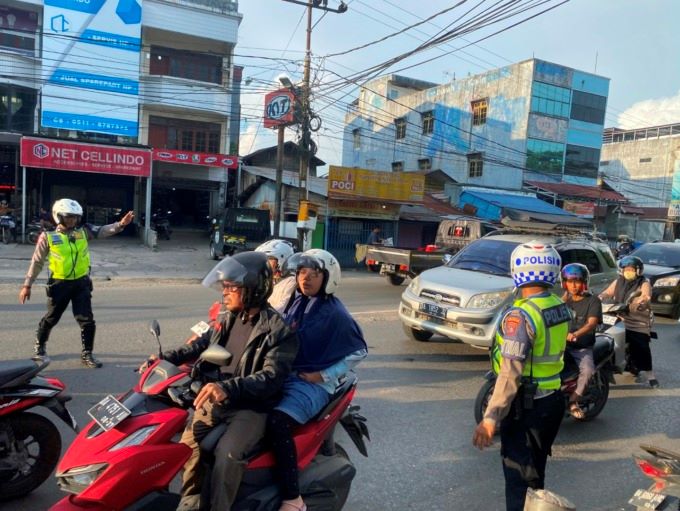 ATUR ARUS: Polantas mengatur arus lalu lintas di jalan raya Kota Banjarmasin. | FOTO: M OSCAR FARABY/RADAR BANJARMASIN