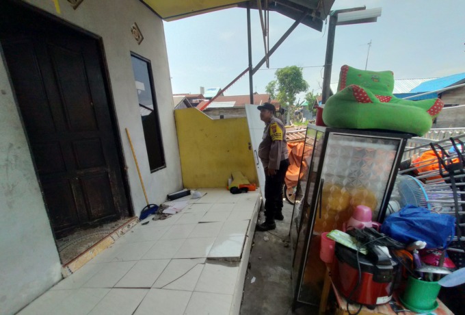 DOYONG: Bhabinkamtibmas Kuin Cerucuk mengecek kondisi indekos miring di Gang Karya 8, kemarin (11/10). | FOTO: WAHYU RAMADHAN/RADAR BANJARMASIN