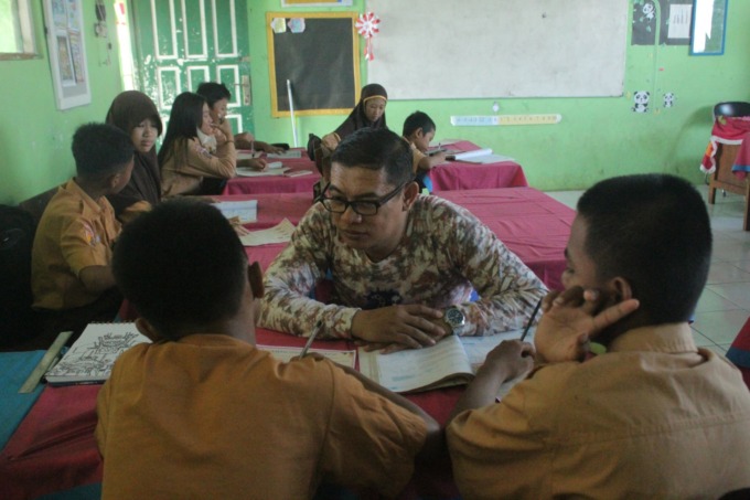MENDAMPINGI: Hafiz memberikan pelajaran kepada dua murid ABK di SDN 1 Guntung Paikat Kota Banjarbaru, Rabu (25/10). | FOTO: BAYU ADITYA RAHMAN/RADAR BANJARMASIN