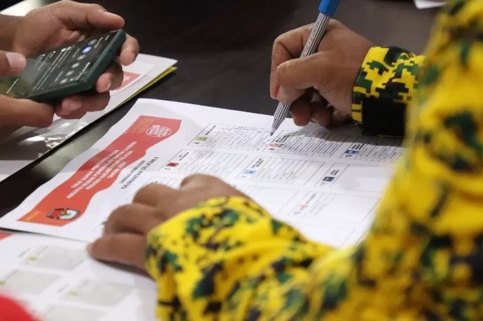 TANDA TANGAN: Para saksi menandatangani dokumen saat pemilu. (M OSCAR FRABY/RADAR BANJARMASIN)