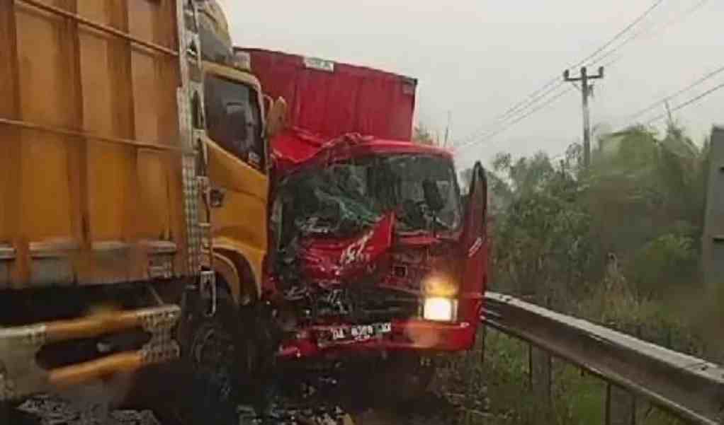 SOPIR TERJEPIT : Kondisi mobil truk box yang terlibat adu banteng dengan truk fuso jalan nasional di Desa Sabuhur, Kecamatan Jorong. Sopir truk ekspedisi terjepit di dalam kabin. (Grup R2T)