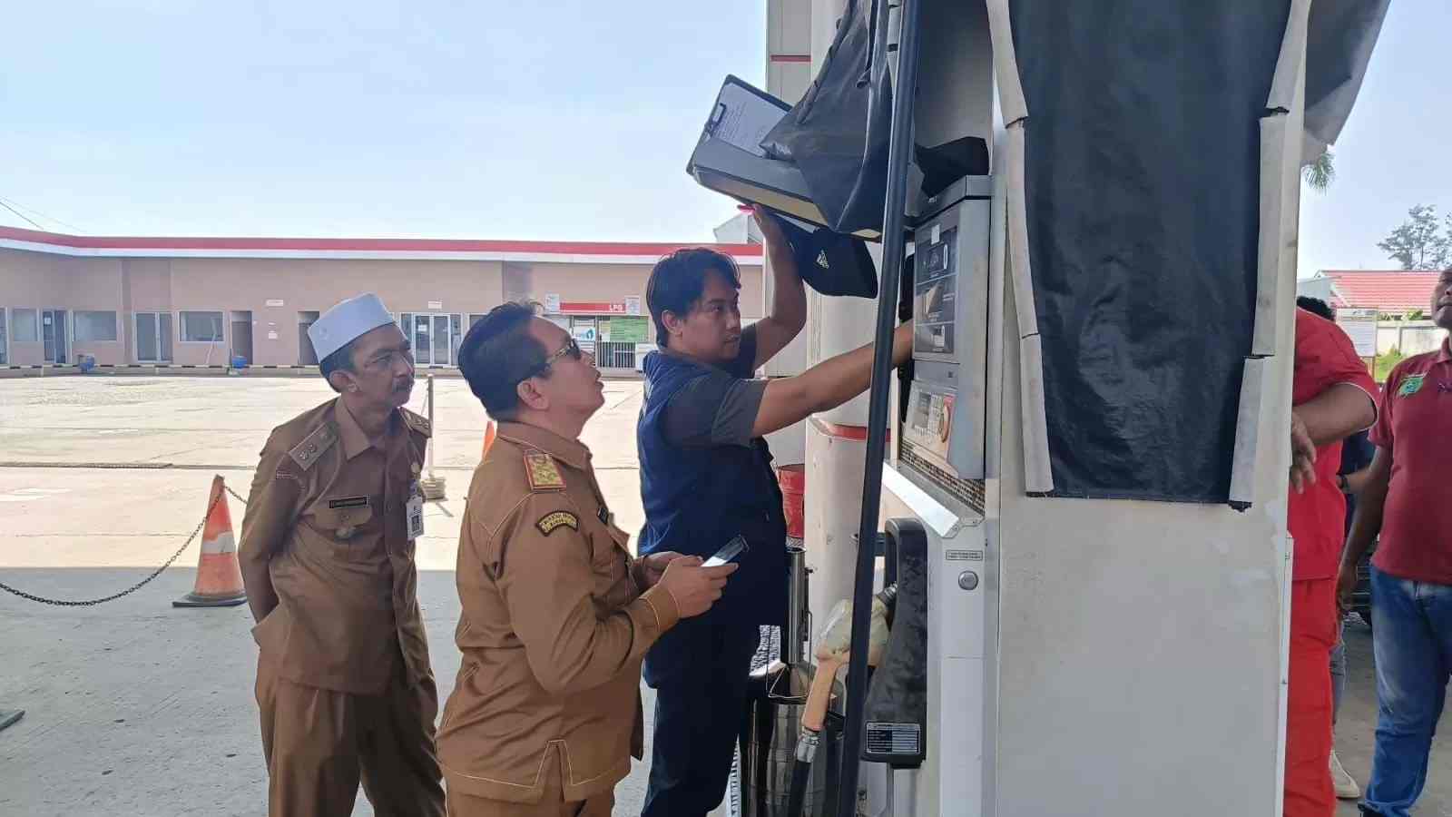 JELANG NATARU: Kepala DKUMP2 Tanah Bumbu Hamaluddin Taher (kanan) mengawasi alat ukur pendistribusian BBM di salah satu SPBU di Simpang Empat, Selasa (19/12). - (DKUMP2 TANAH BUMBU/RADAR BANJARMASIN)