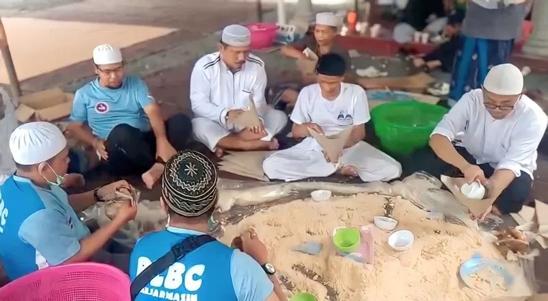 MEMBUNGKUS: Relawan Haul Guru Sekumpul sedang mempersiapkan nasi samin yang dibungkus dengan kertas minyak pada haul ke-15 tahun 2020 lalu. (FOTO: DOKUMEN RADAR BANJARMASIN)