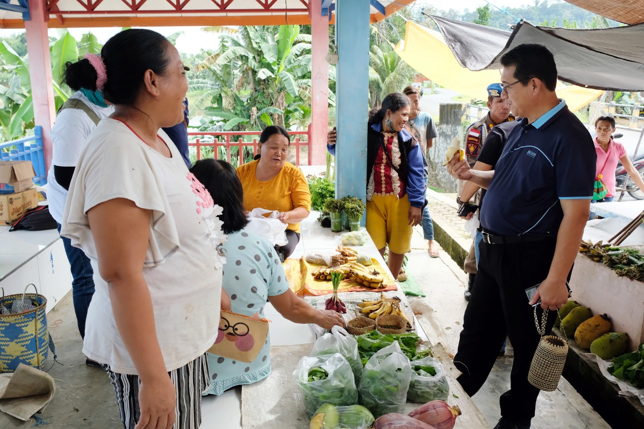 BERPOTENSI: Bupati Malinau Dr. Yansen TP, M.Si saat bersenda gurau dengan pedagang Pasar Inai sambil memakan pisang hasil dari masyarakat lokal. Banyak potensi pertanian hingga beras daerah yang bisa menjadi andalan Kabupaten Malinau. FOTO: AGUSSALAM SANI