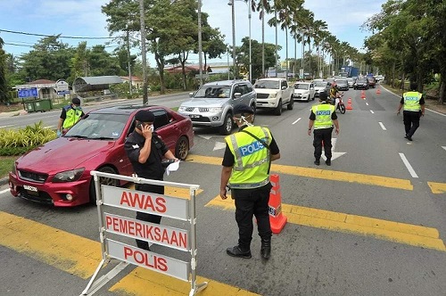 Polisi Diraja Malaysia (PDRM) memeriksa penumpang di Jalan Tun Mustapha, Labuan. (BERNAMA)