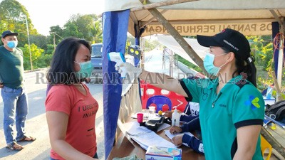 CEGAH CORONA: Tim Gugus Tugas Penanganan Covid-19 memeriksa suhu tubuh setiap warga yang masuk ke KTT.  FOTO: RIKO/RADAR TARAKAN