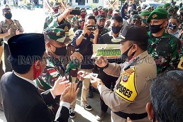 SINERGI: Kapolres Malinau AKBP Agus Nugraha saat menyerahkan potongan kue pertama kepada Dandim 0910 Malinau Letkol Inf. Nopid Arif dalamrangka peringatan Hari Bhayangkara ke-74 di Mapolres Malinau, Rabu (1/7)../ASRULLAH/RADAR KALTARA