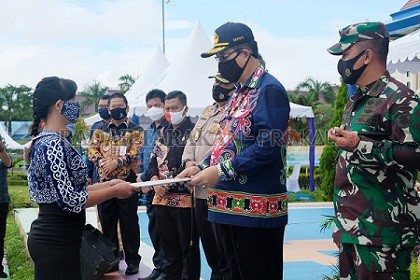 TERIMA SK: Bupati Malinau Dr. Yansen TP, M.Si menyerahkan SK secara simbolis kepada Satgas Gerdema yang akan bertugas mendampingi desa dan RT, di acara pembukaan Bulan Bakti RT Bersih Tahun 2020, Selasa (14/7) di halaman kantor Bupati Malinau./AGUSSALAM S