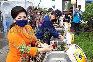 KEBIASAAN BARU: Bupati Malinau Dr. Yansen TP, M.Si bersama istri mencuci tangan di pintu gerbang sebelum masuk ke lingkungan kantor Bupati Malinau./AGUSSALAM SANIP/RADAR TARAKAN