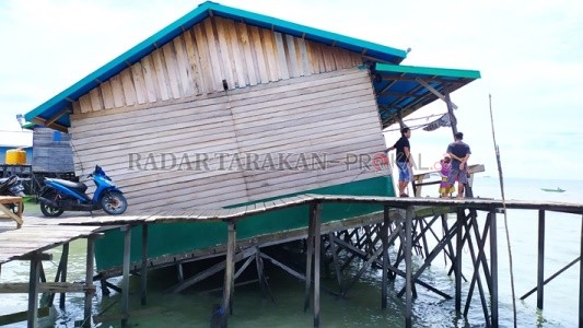 NYARIS AMBRUK: Salah satu pos pembelian udang milik warga di RT 25, Karang Anyar, Tarakan Barat, mengalami kemiringan saat puncak rob, Senin (19/10) pagi./IFRANSYAH/RADAR TARAKAN