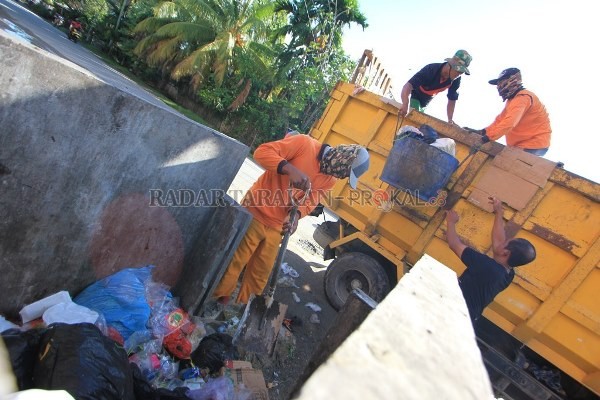 DIANGKUT: Petugas pengangkut sampah saat mengangkut sampah ke dalam bak armadanya./BANK DATA RADAR KALTARA