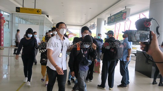 DITANGKAP: Kedua pelaku yang digiring pihak kepolisian setelah tiba di Bandara Juwata kemarin (24/2)./ELIAZAR/RADAR TARAKAN