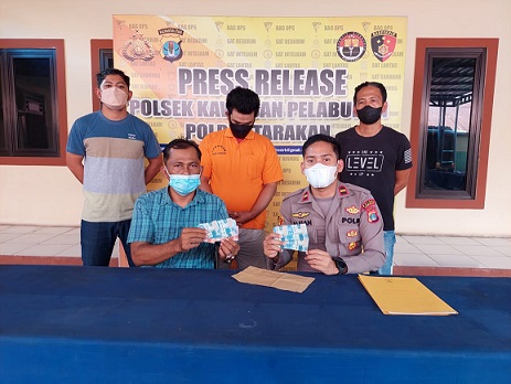 TERTANGKAP: Kapolsek KSKP IPDA Alfian Yusuf memperlihatkan barang bukti dan tersangka calo pengurusan sertifikat vaksin. ELIAZAR/RADAR TARAKAN