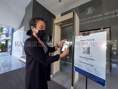 DITERAPKAN: Salah satu pegawai Kantor Perwakilan Bank Indonesia Kaltara melakukan scan barcode aplikasi PeduliLindungi. FOTO: ELIAZAR/RADAR TARAKAN
