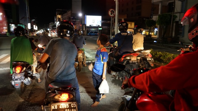 MENGASONG: Salah seorang anak terlihat masih menjajakan dagangannya hingga malam di salah satu ruas jalan di Tarakan. FOTO: AGUS DIAN ZAKARIA/RADAR TARAKAN
