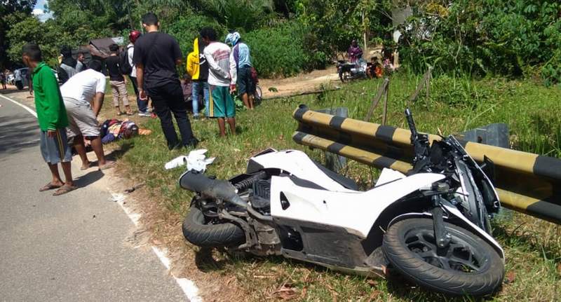 TKP: Seperti inilah kondisi sepeda motor korban tabrakan di depan objek wisata Bukit Batu Katingan. Sementara sejumlah warga melihat kondisi korban, Senin (15/3). SATLANTAS POLRES KATINGAN